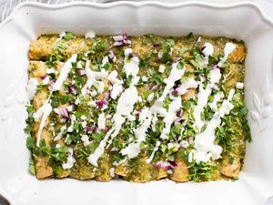 Finished Enchiladas Verdes Recipe Garnished with cheese, red onion, and fresh cilantro