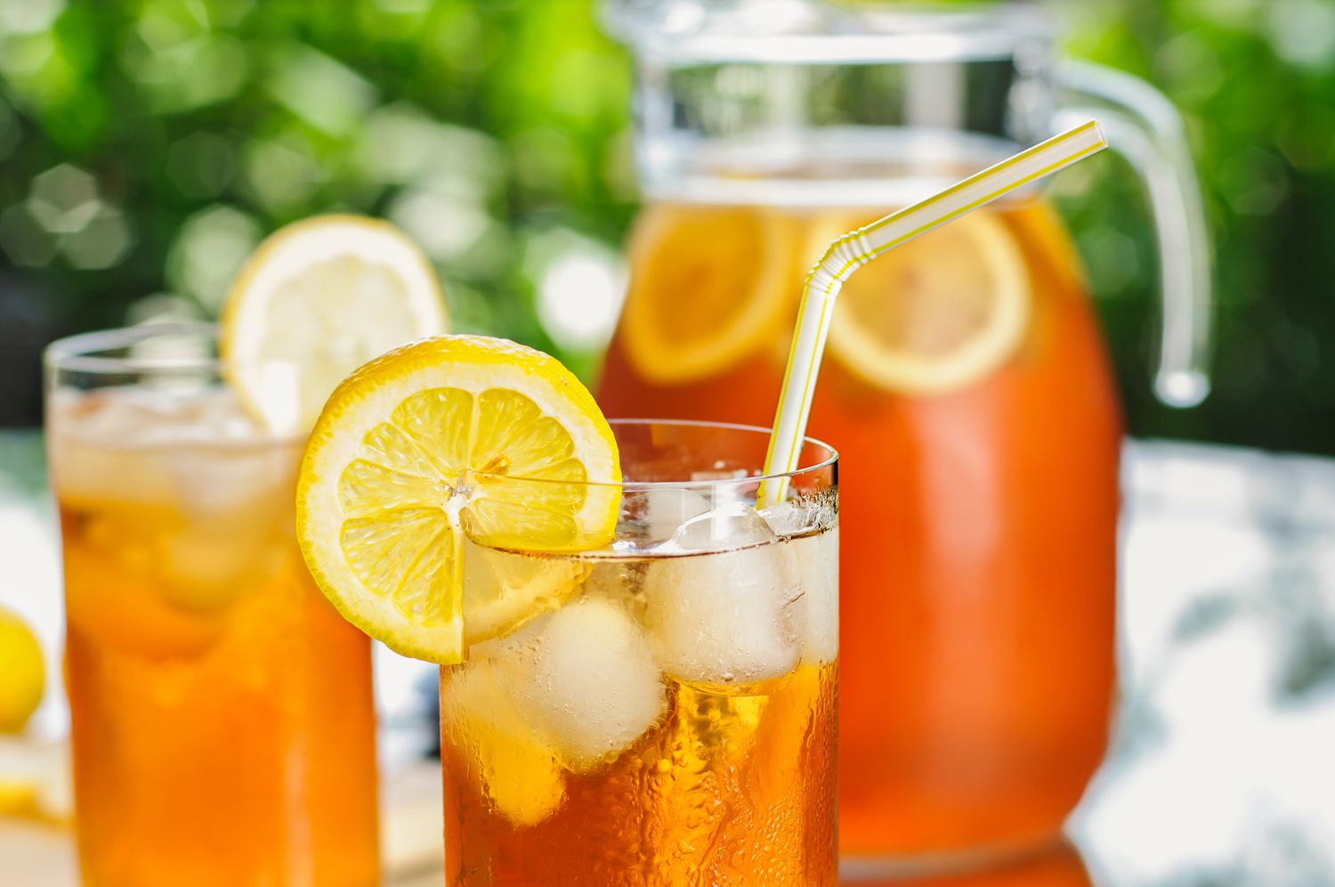 glasses and a pitcher filled with iced tea 