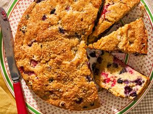 berry buckle (some of cut into slices) on a plate at a cozy table setting (cottagecore vibes)