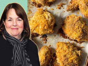 Ina Garten with a tray of baked chicken pieces