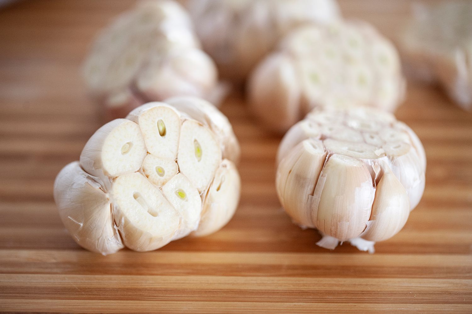 Fresh garlic with the cloves exposed and set on a wooden background.