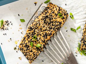 A sesame-crusted salmon filet being served with scallions