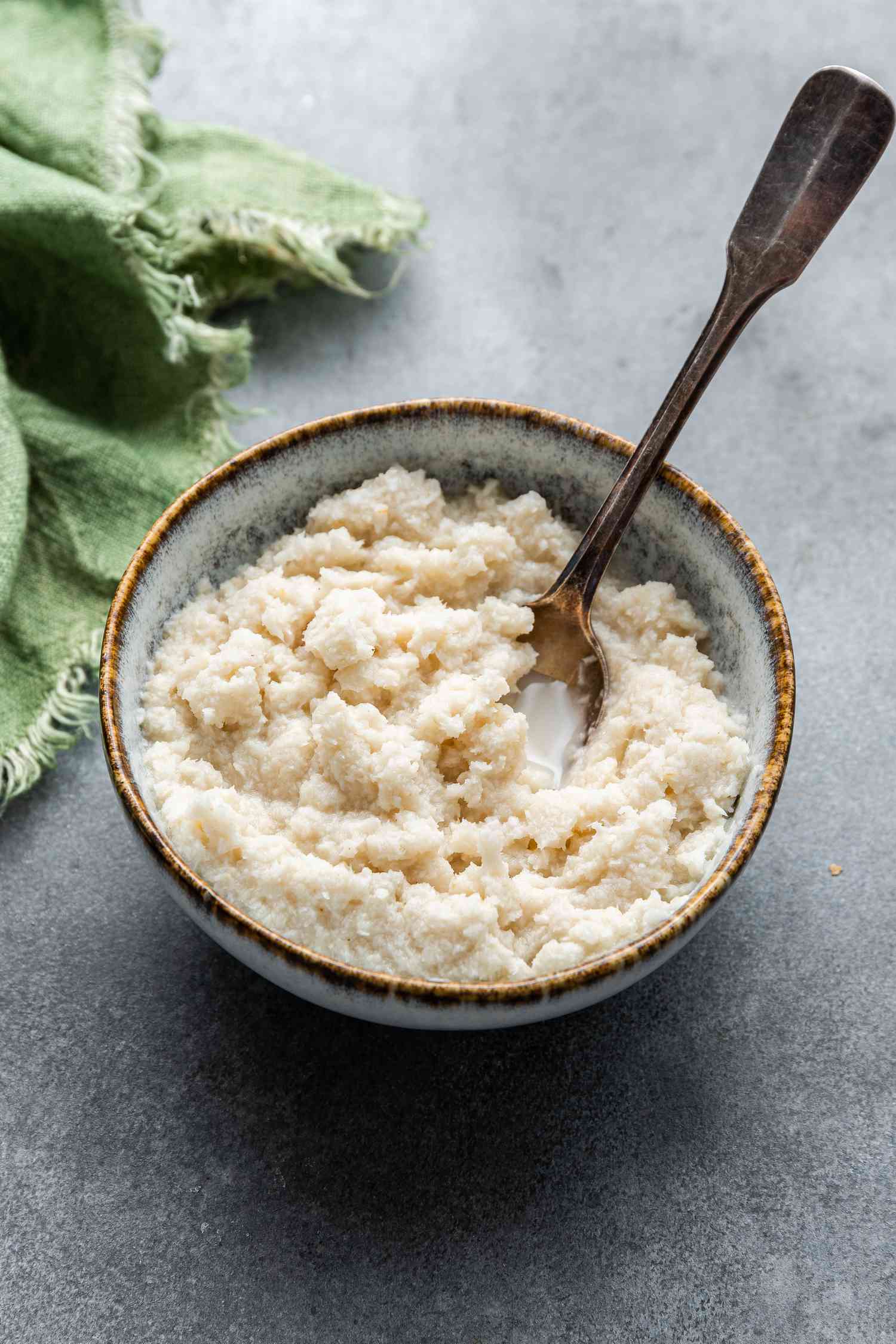 A bowl of Homemade Prepared Horseradish with a spoon in it