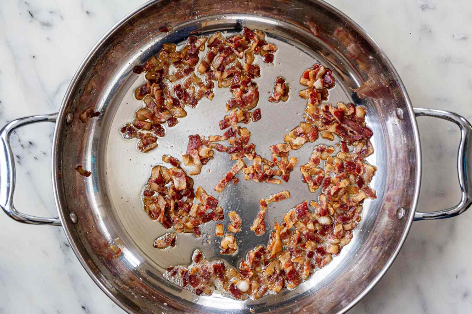 Browning bacon in a pot to make a coq au vin recipe.