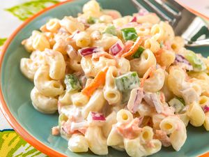 Plate of creamy macaroni salad on a table with a fork