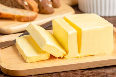 stick of butter on a butter dish, 3 slices cut into it