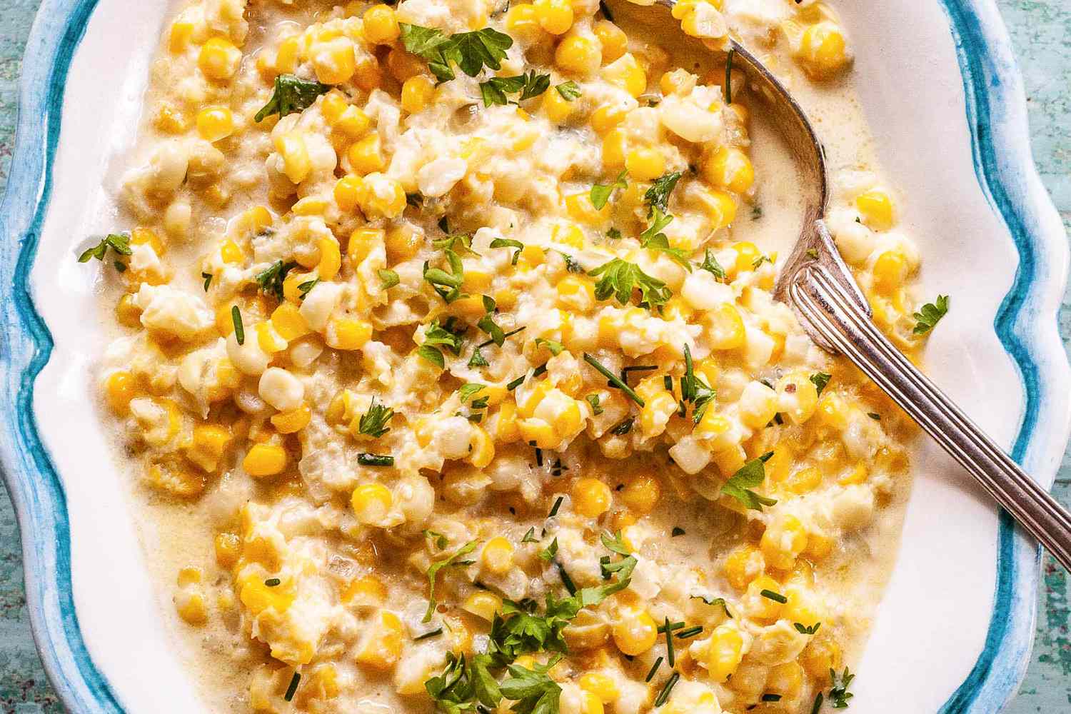 creamed corn in a white bowl with light blue trim