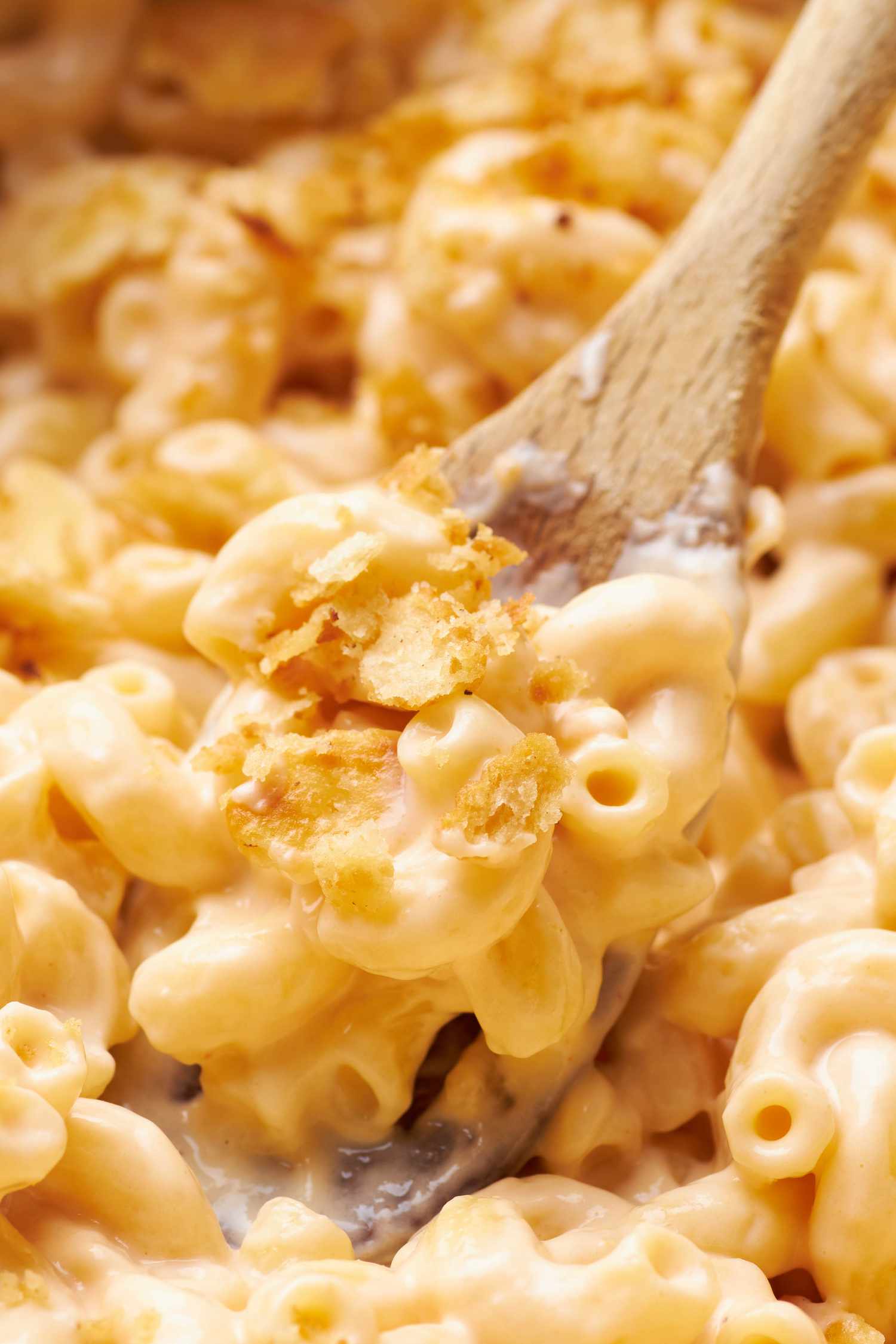 Close-up: spoon lifting some one pot mac and cheese with cracker topping