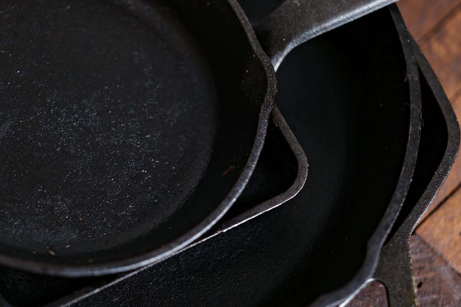 How to Clean a Cast Iron Skillet - close up of cast iron pans stacke don top of each other.