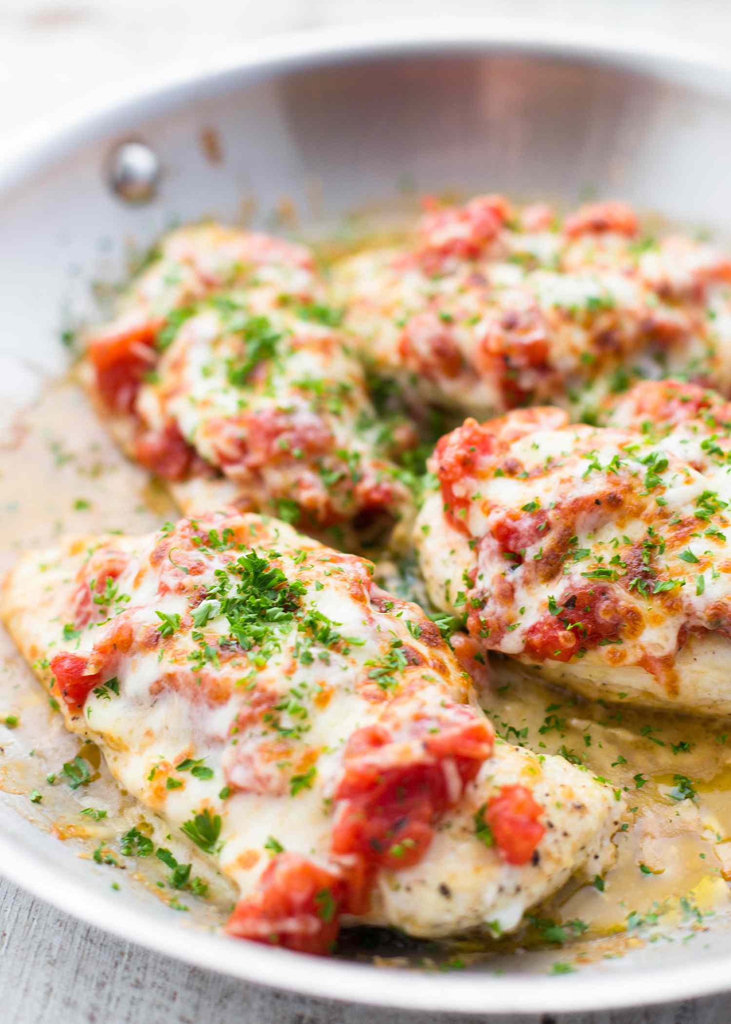 Chicken Cutlets topped with tomato bruschetta in a skillet