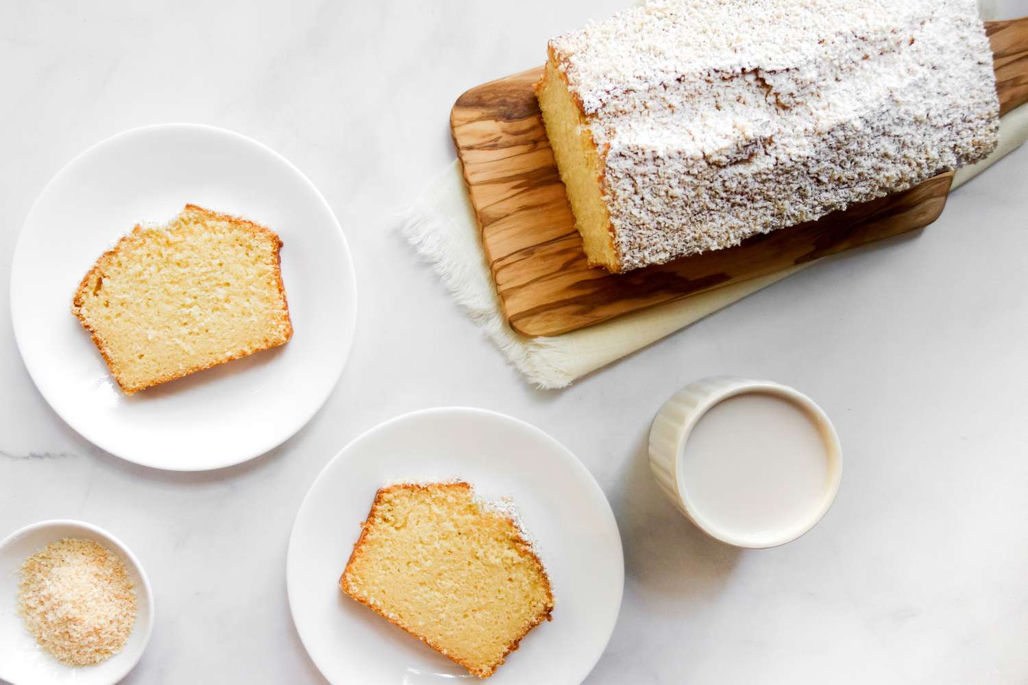 Sliced coconut pound cake on dessert plates.