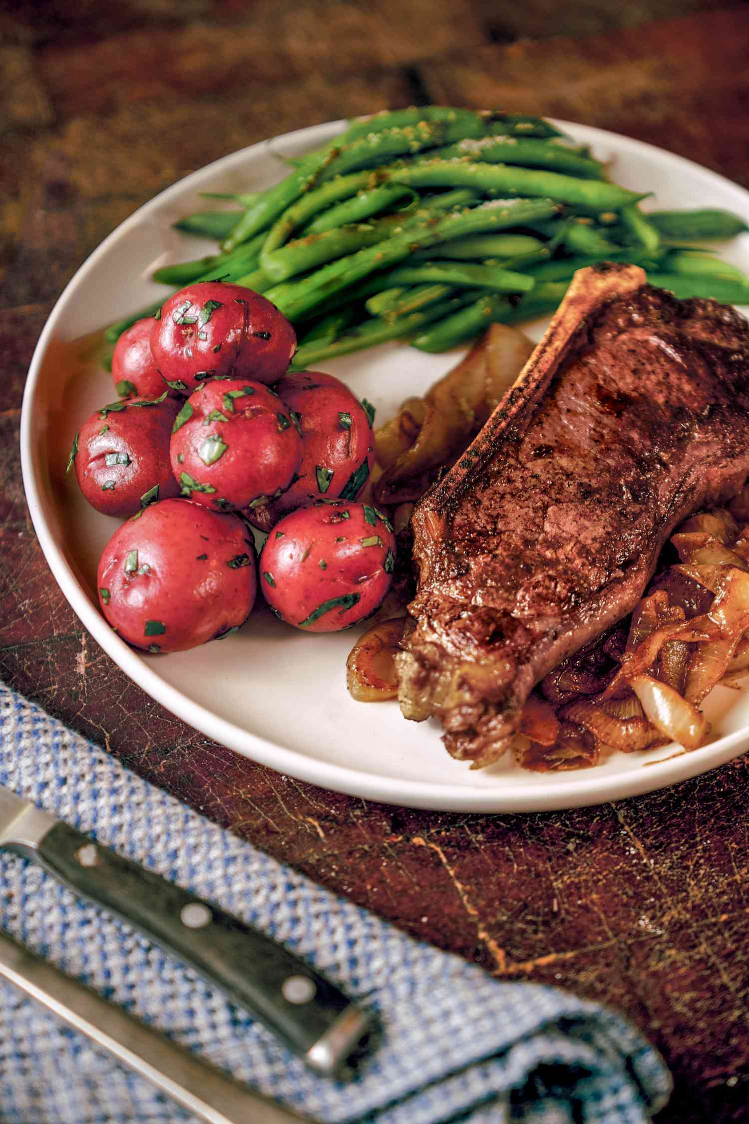 Steak with sweet onions served with red potatoes and green beans
