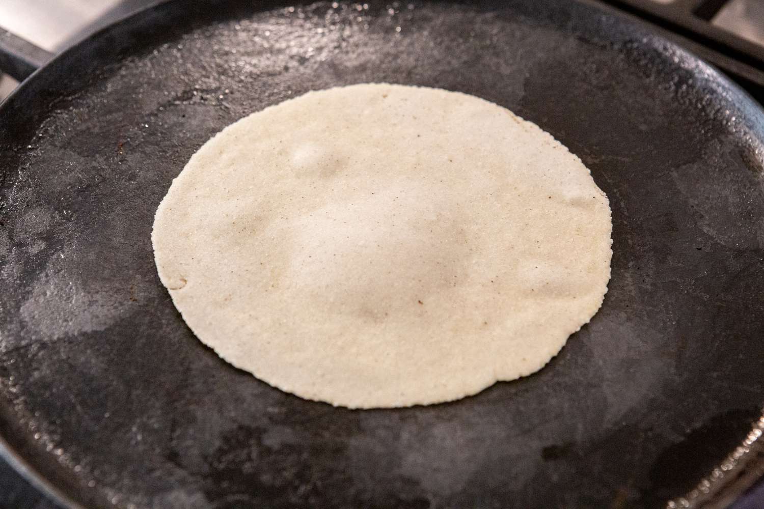 Cooking a tortilla on a hot skillet