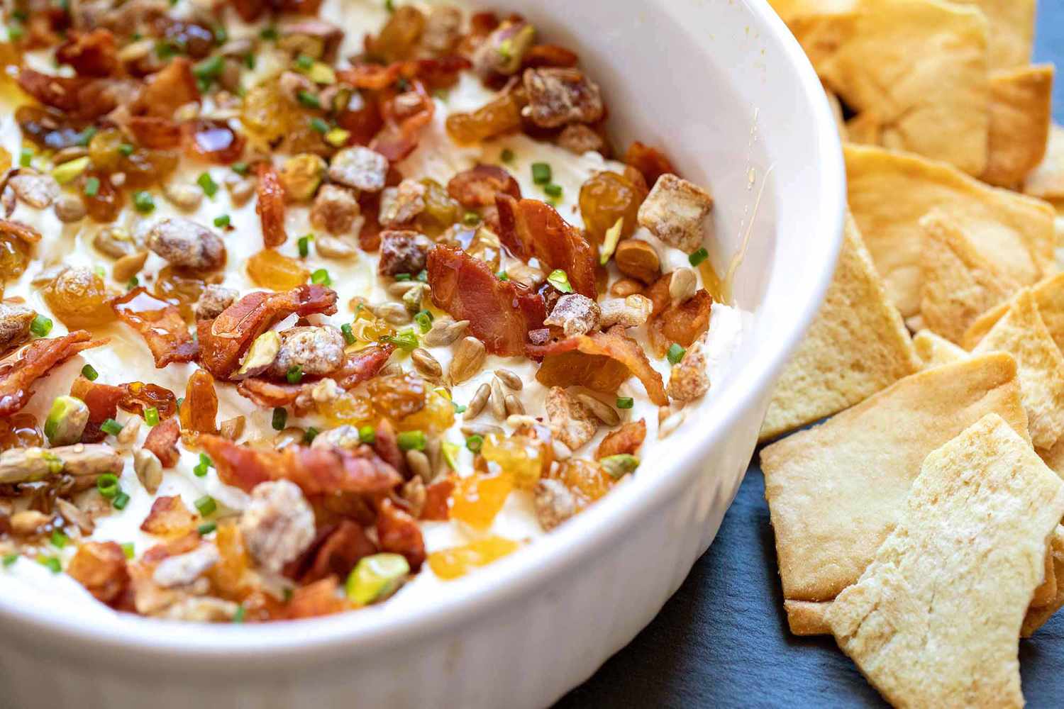 Goat Cheese 7 layer Dip in a baking dish with pita chips