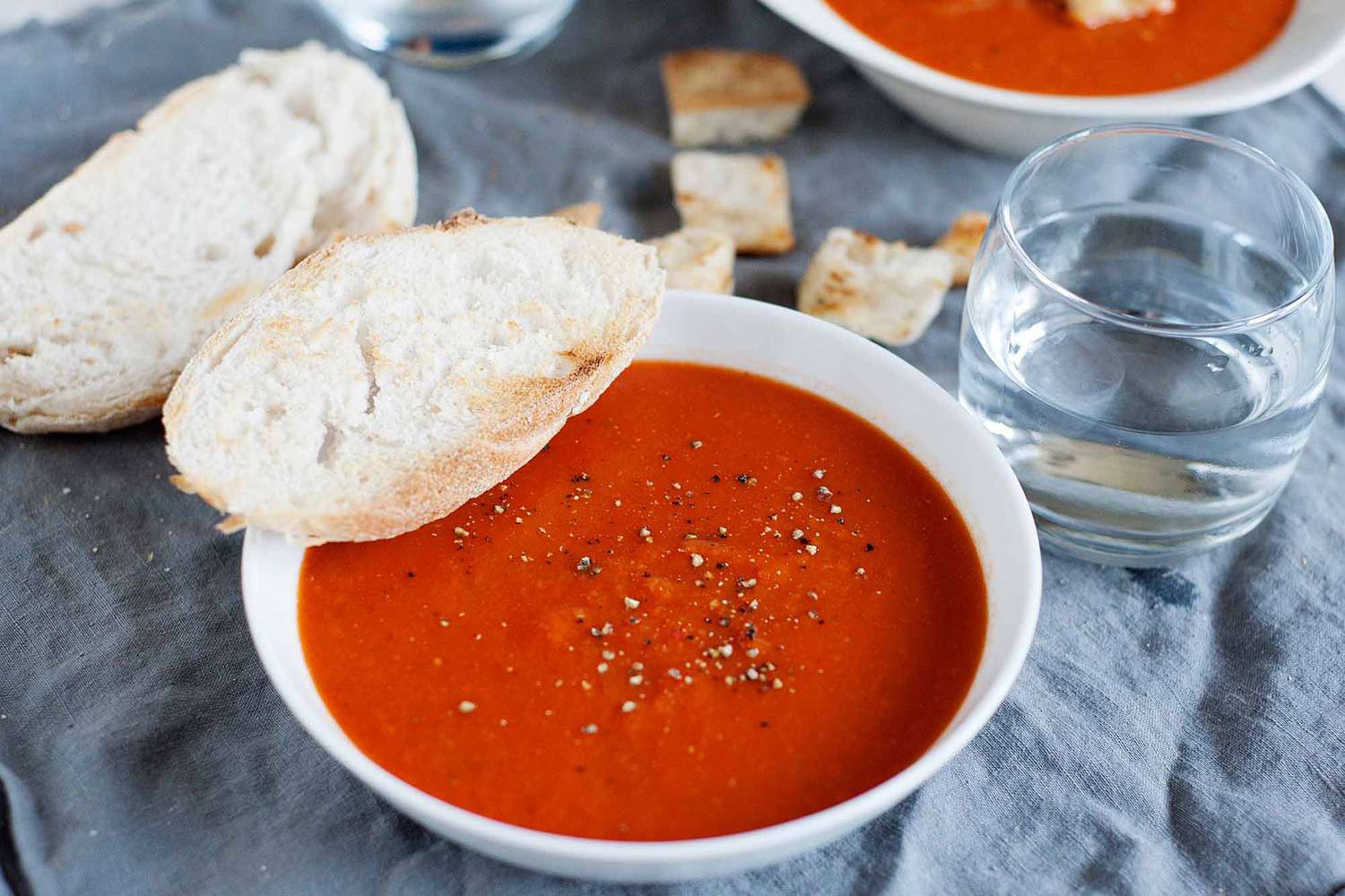 Best Tomato Soup Recipe - bowls of tomato soup on table with bread
