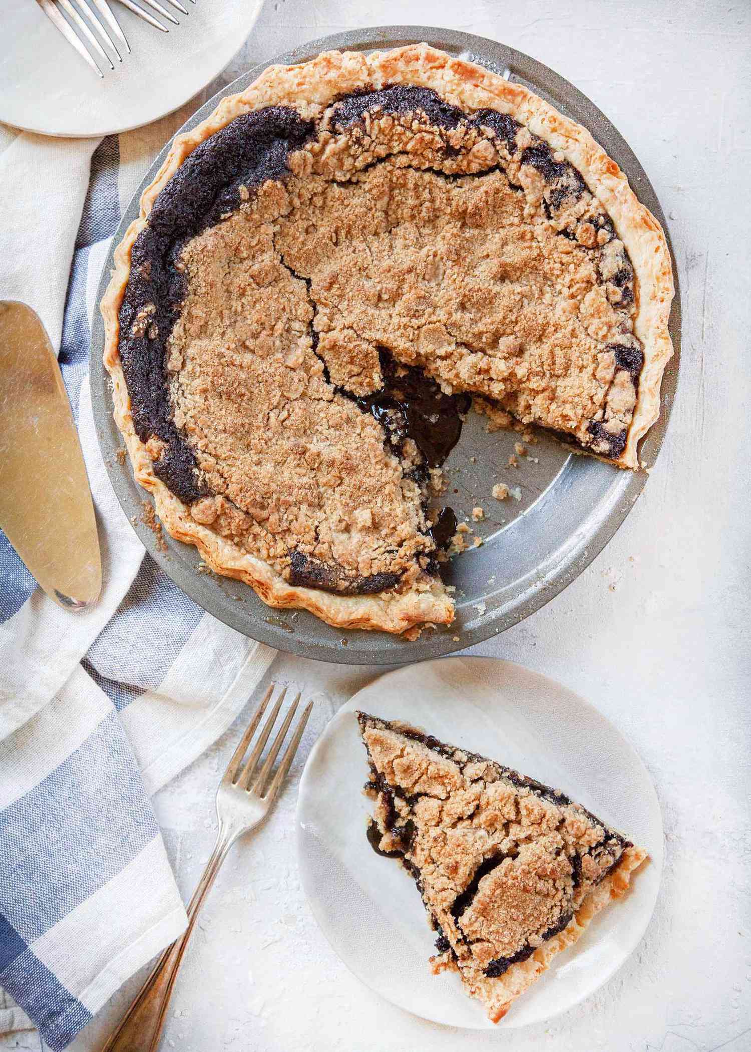 Overhead view of shoo-fly pie with a piece removed and set on a white plate.