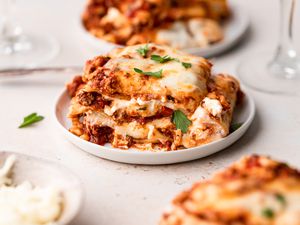 Side view of a piece of lasagna on a plate.