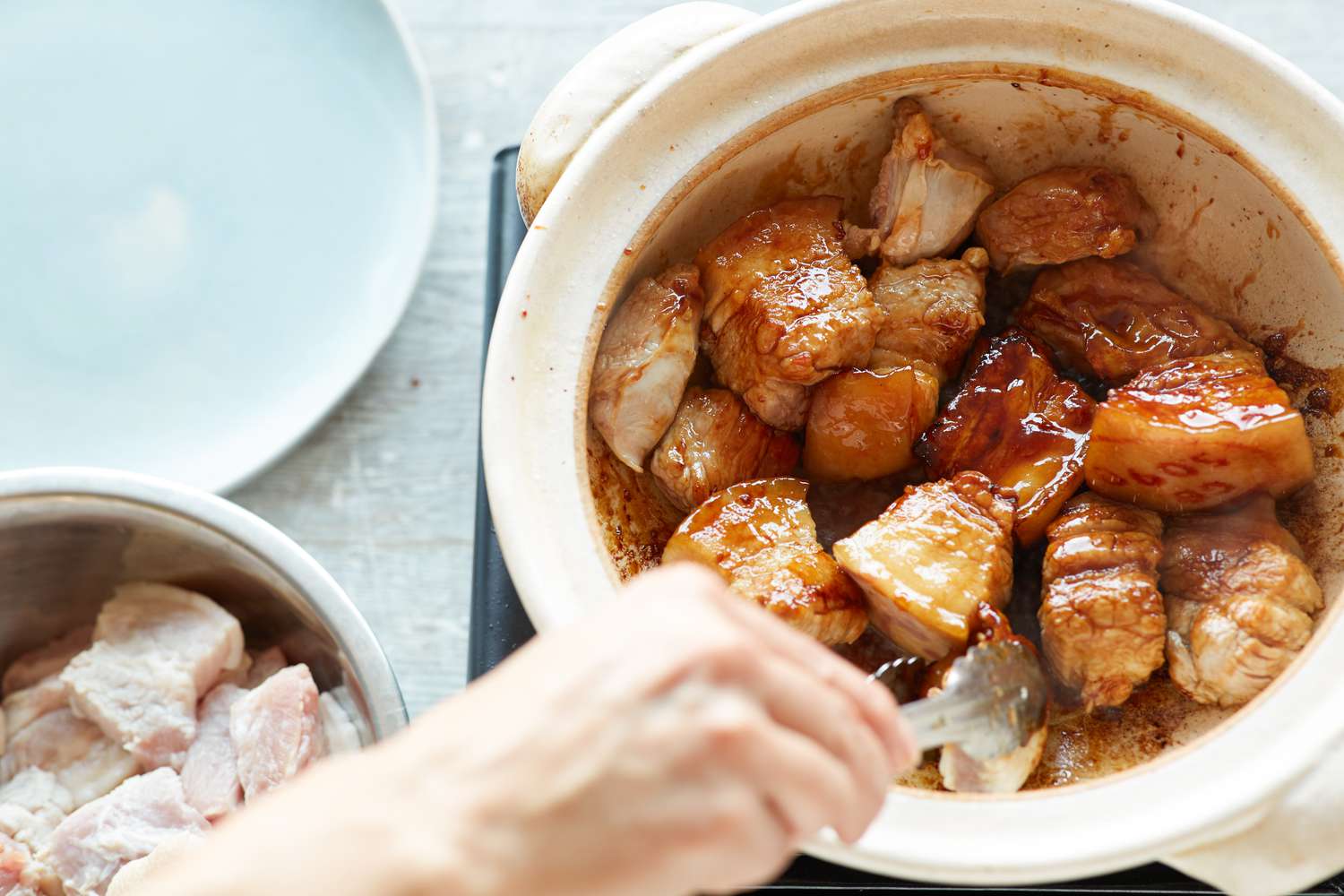Searing pork belly to make pork belly and eggs braised in sweet coconut water