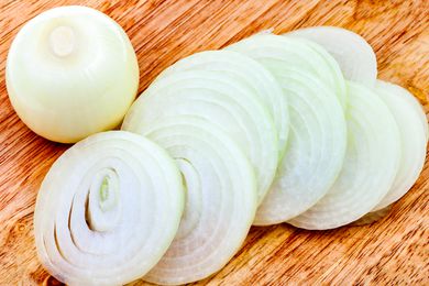 A sliced white onion on a cutting board