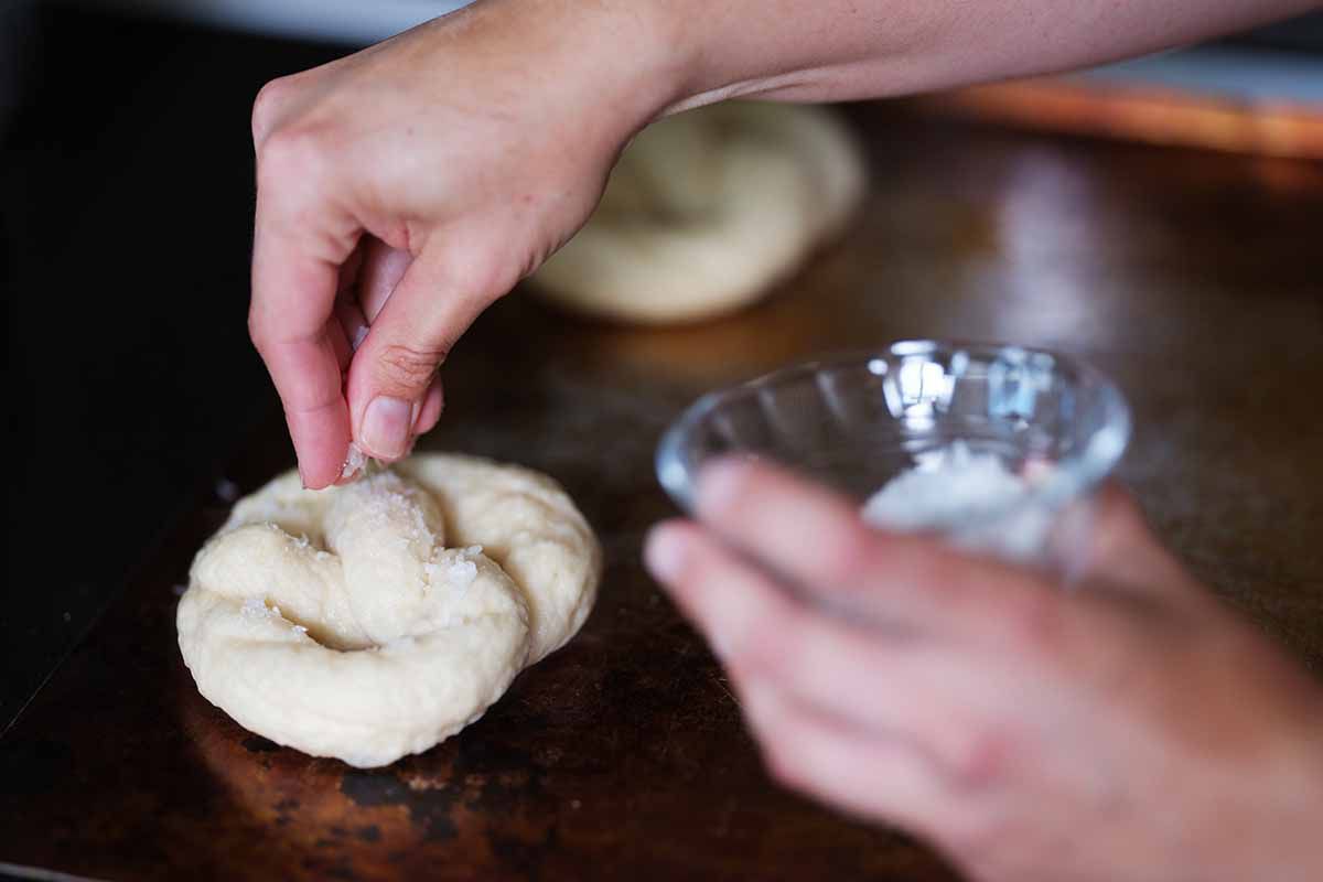 Sprinkle the boiled pretzels with flaky salt