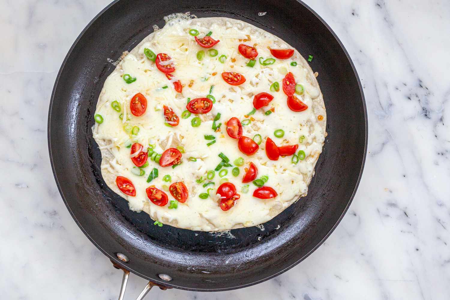 A tortilla in a skillet to show how to make quesadillas.