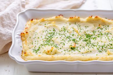 A casserole dish of make-ahead mashed potatoes with minced fresh chives on top