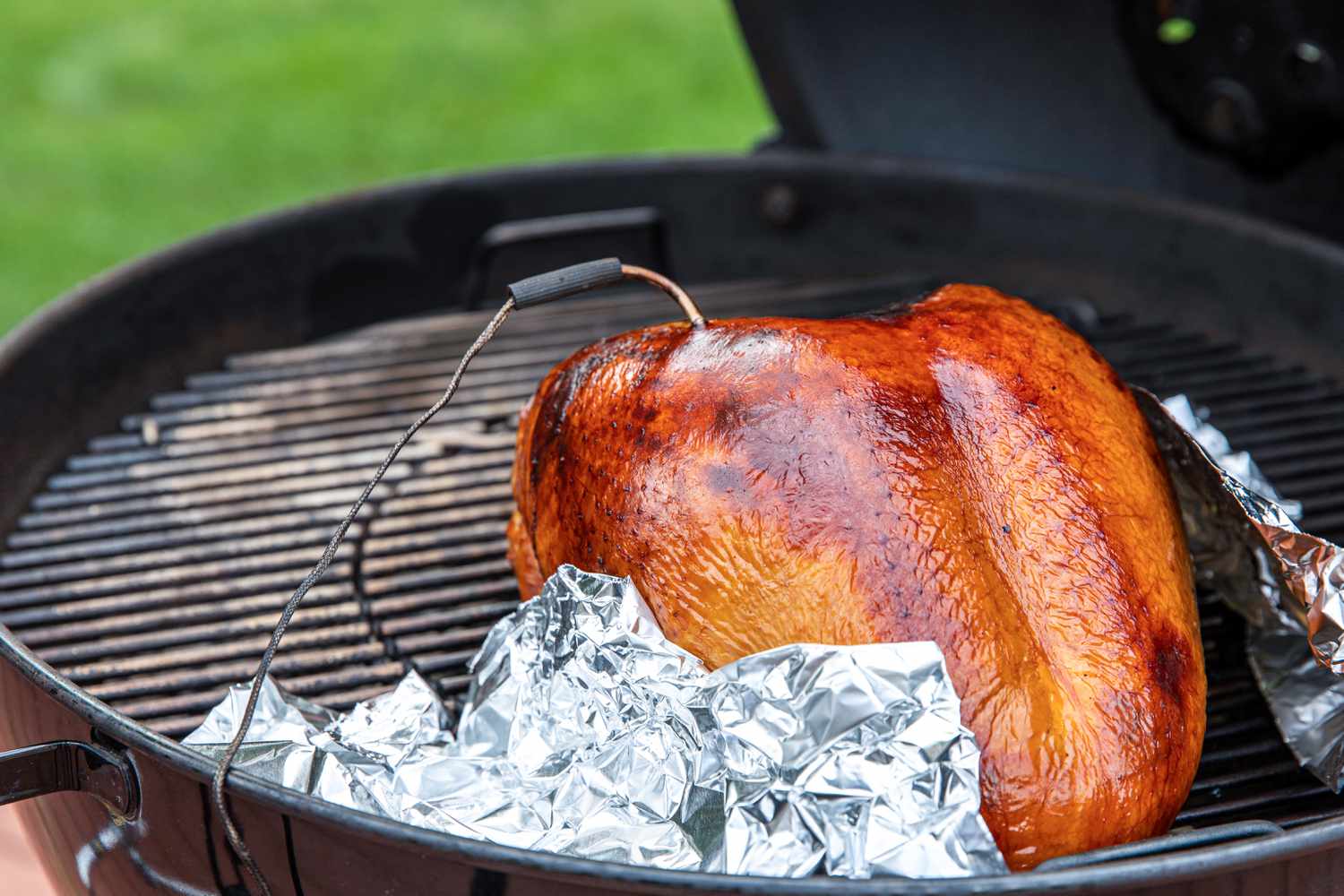 Checking the internal temperature of an apple and sage-brined smoked turkey breast