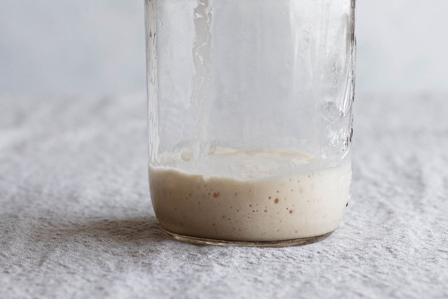 Simple sourdough starter seen up close in a mason jar.