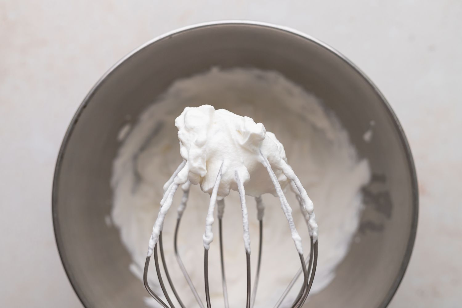 Whipped cream on a whisk attachment to make a grasshopper pie recipe.