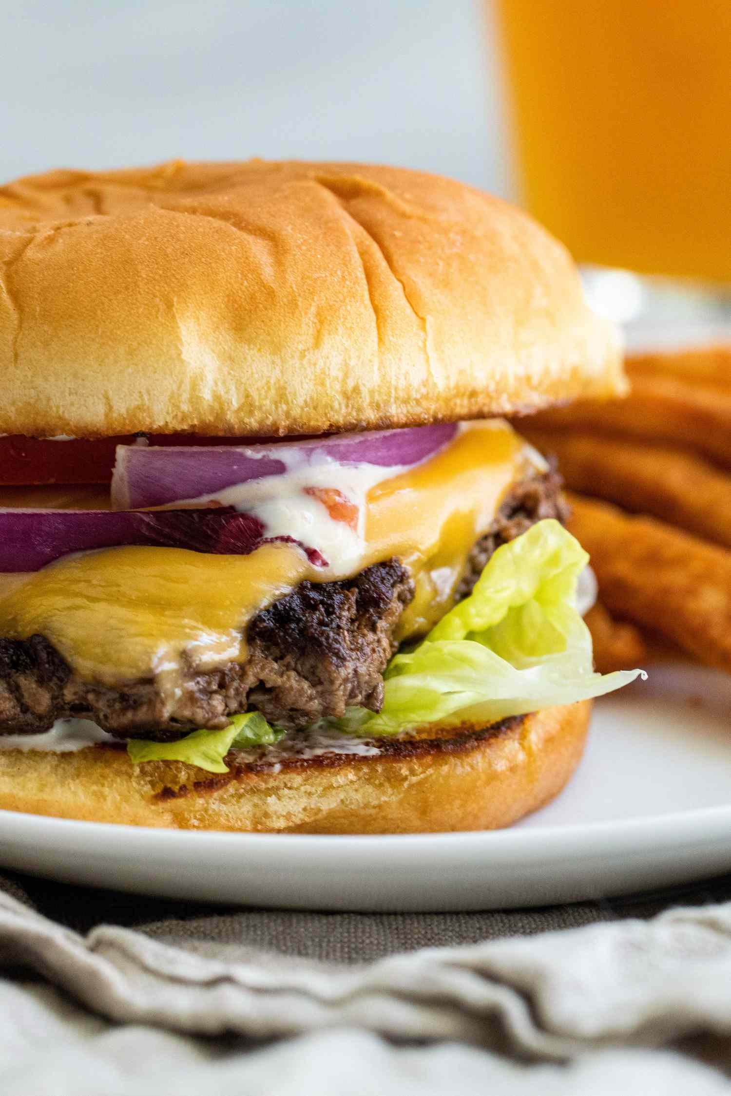 Side view of a homemade smashburger on a plate.
