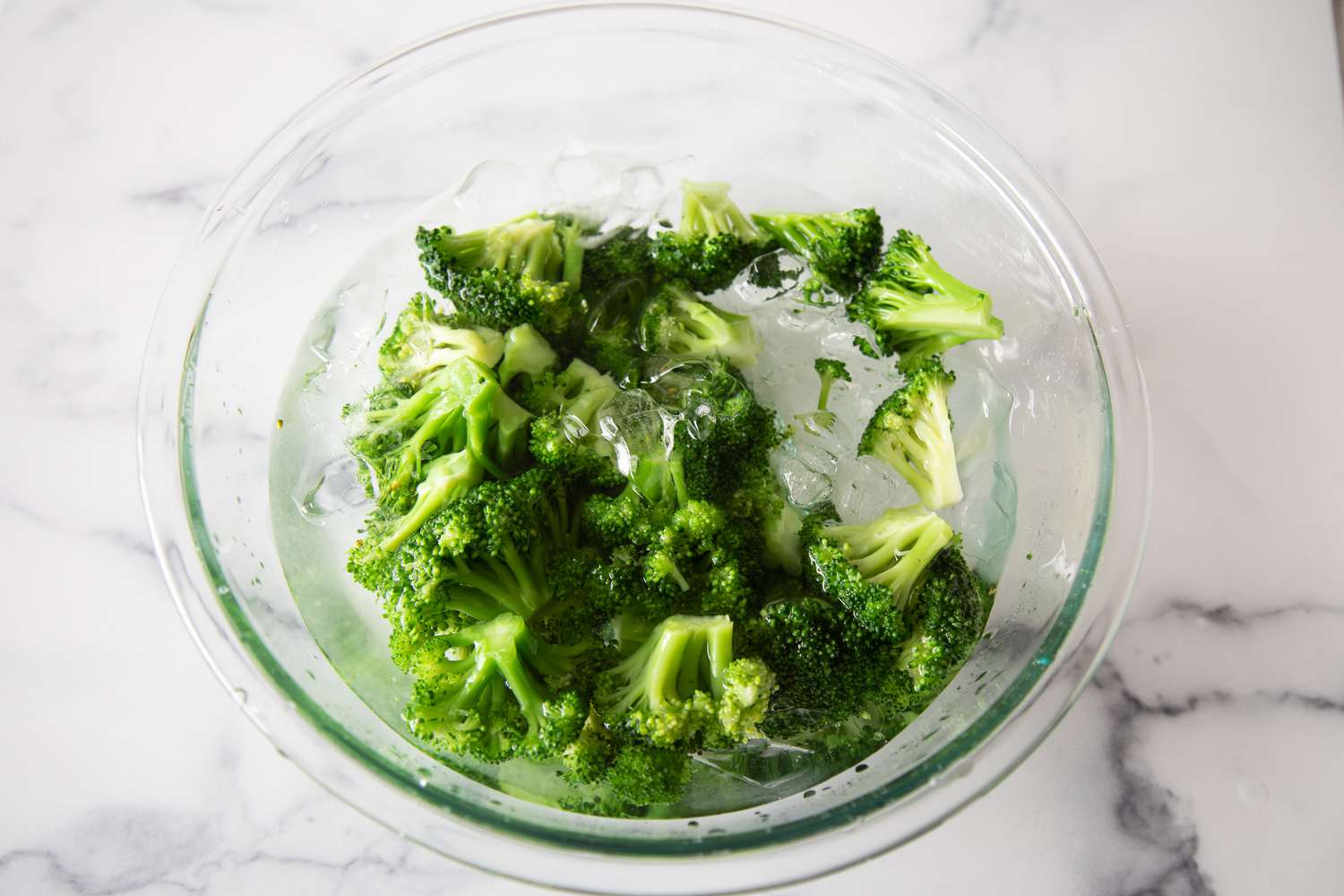 Shocking blanched broccoli in an ice bath for Broccoli Salad