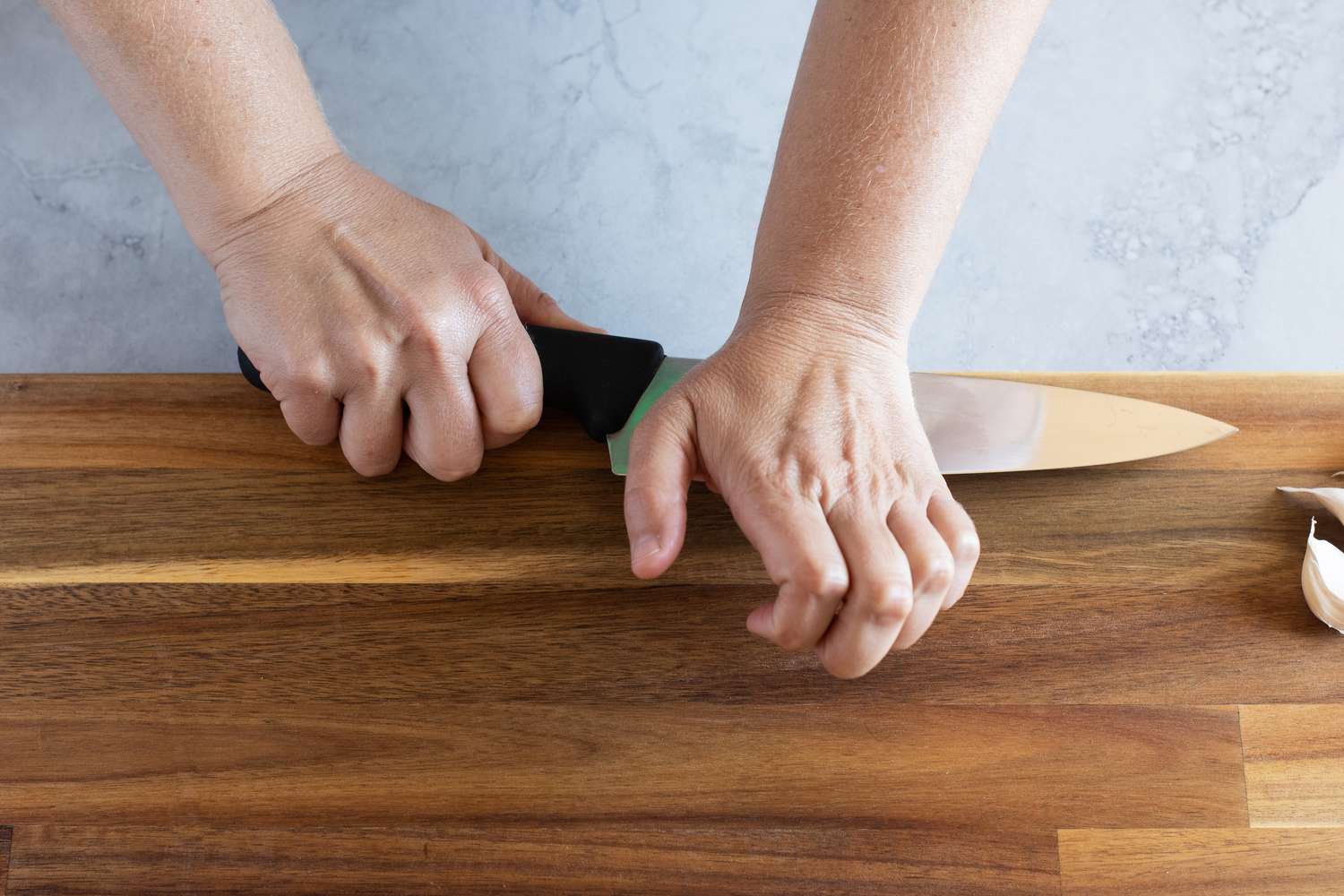 Whacking a chef's knife to peel a clove of garlic