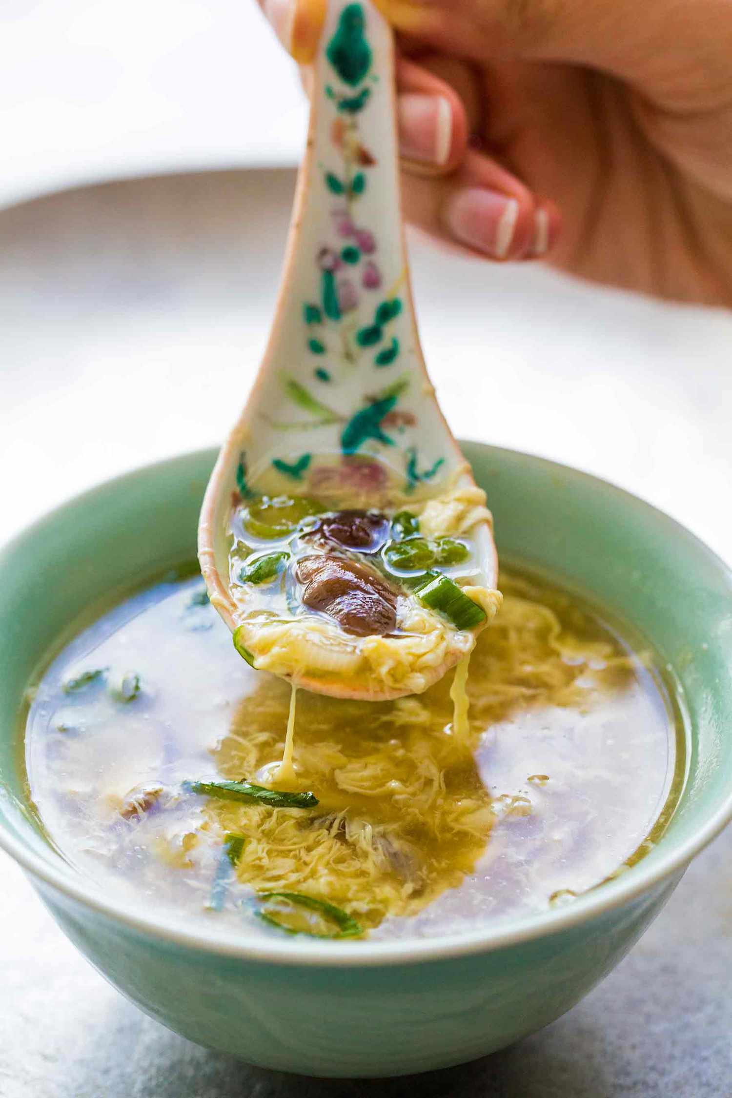 A spoonful of Easy egg drop soup over a bowl
