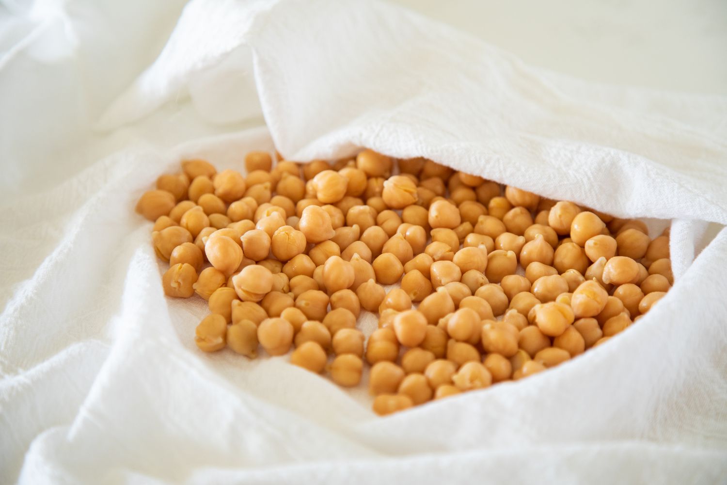 Drying chickpeas in a paper towel to remove all moisture before frying