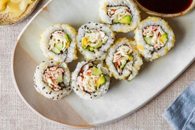 California Rolls on a Plate Next to a Small Bowl of Soy Sauce, Small Bowl of Pickled Ginger, and Small Saucer of Wasabi