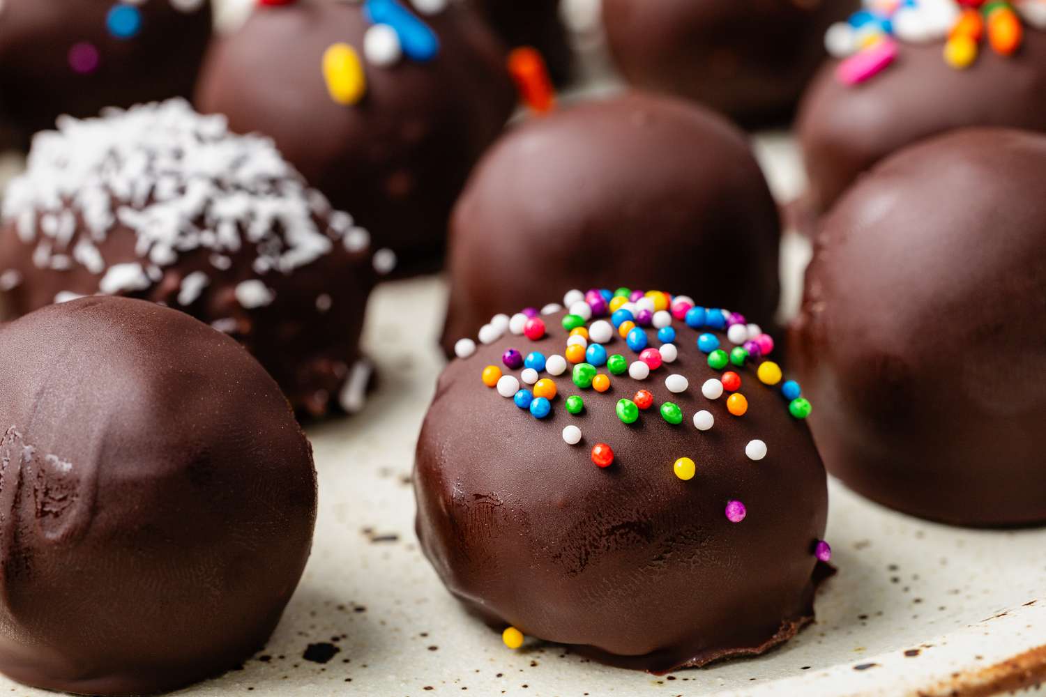 Potato candy (some with toppings, some just covered in chocolate) on a plate
