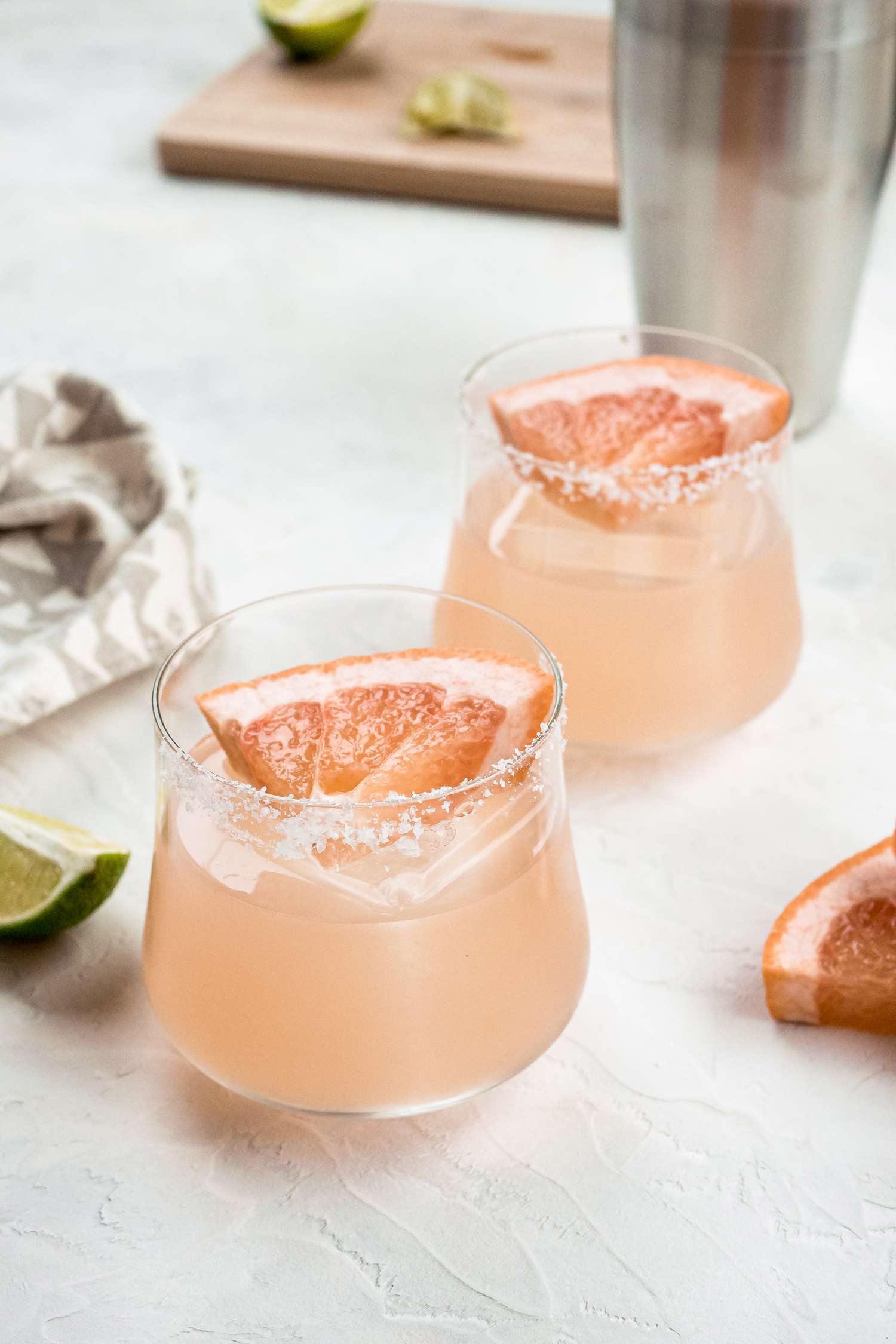 Two delicious grapefruit margaritas garnished with a grapefruit wedge.