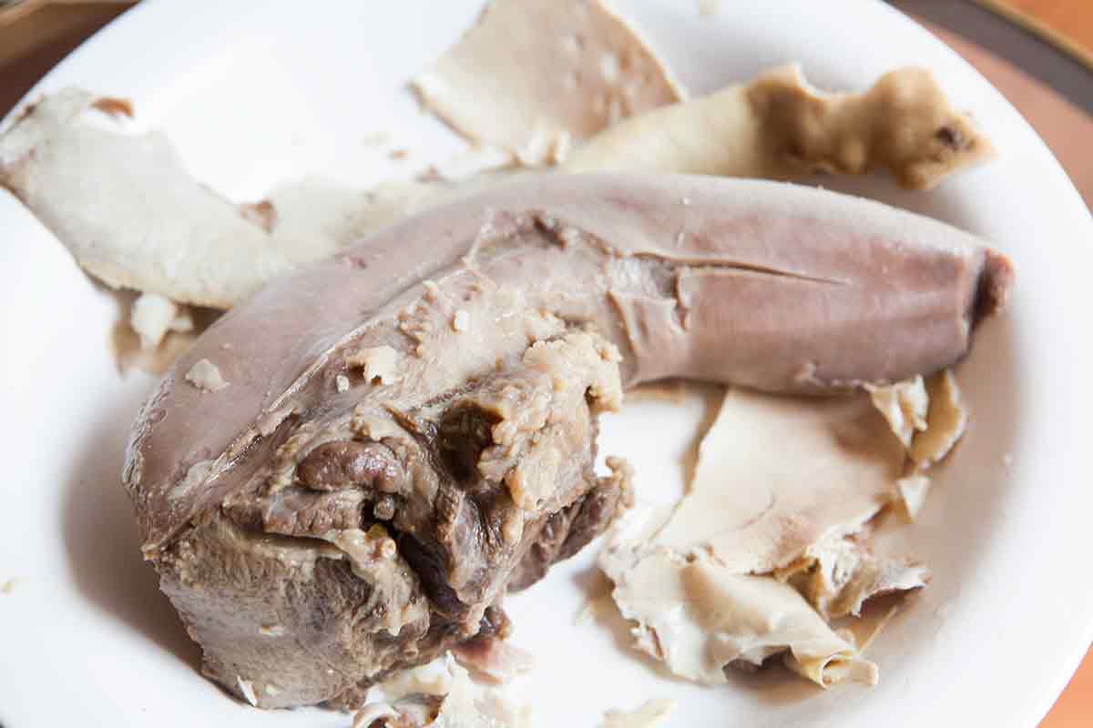 remove all of the light colored skin of the cooked beef tongue