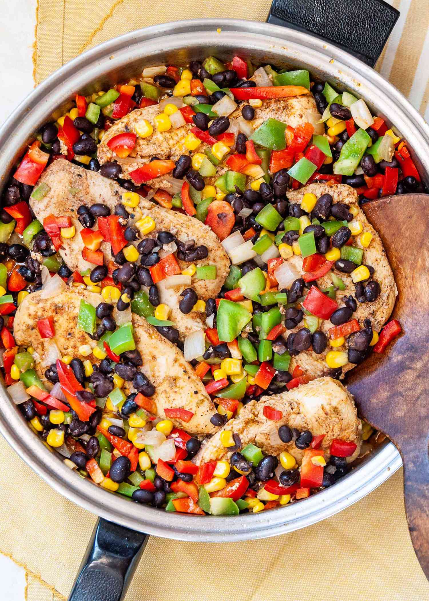 Easy Chicken Freezer Meal with Boneless Skinless Chicken Breast - close up shot of chicken with black beans, red bell pepper, green bell pepper and corn in a skillet
