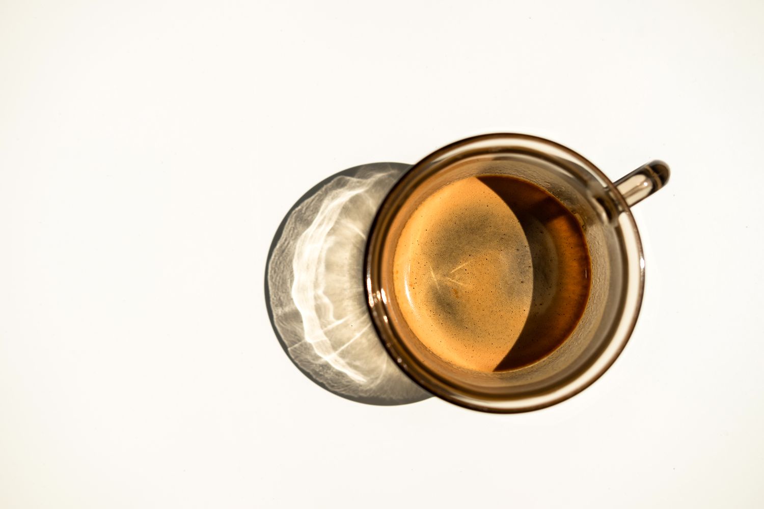 Glass cup of coffee on a white surface