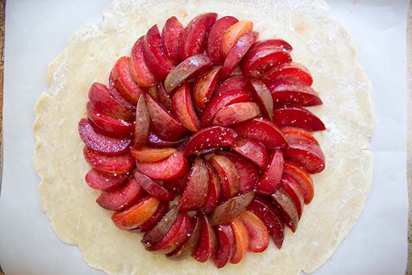 plums on top of a rolled out crust