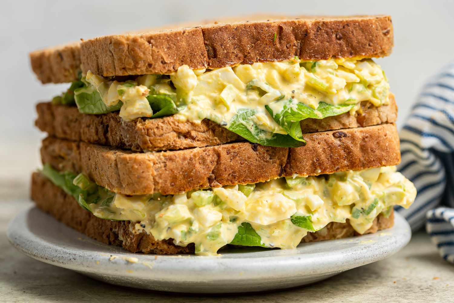 Two egg salad sandwiches stacked on top of each other