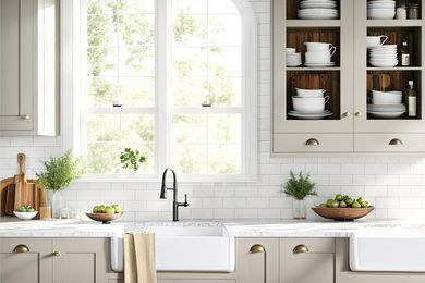 A bright kitchen scene, showing a farmhouse sink, marble countertops, and a subway tile backsplash