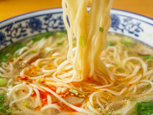 ramen noodles lifted from a bowl ramen with soup