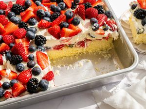 Easy Berry Chantilly Cake in tin, 2 slices removed and one set on a plate