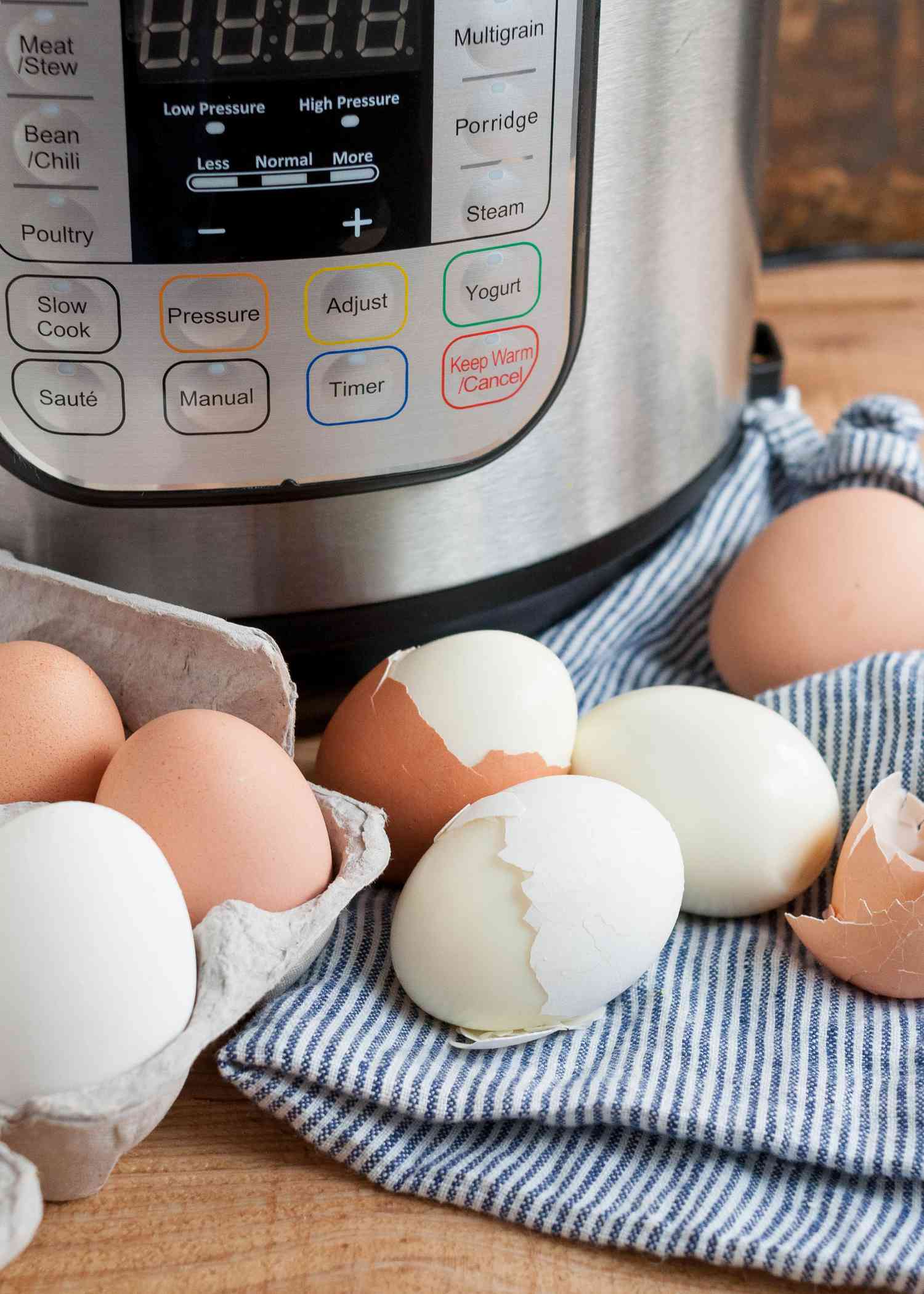 Hard boiled eggs partially peeled in front of an Instant Pot