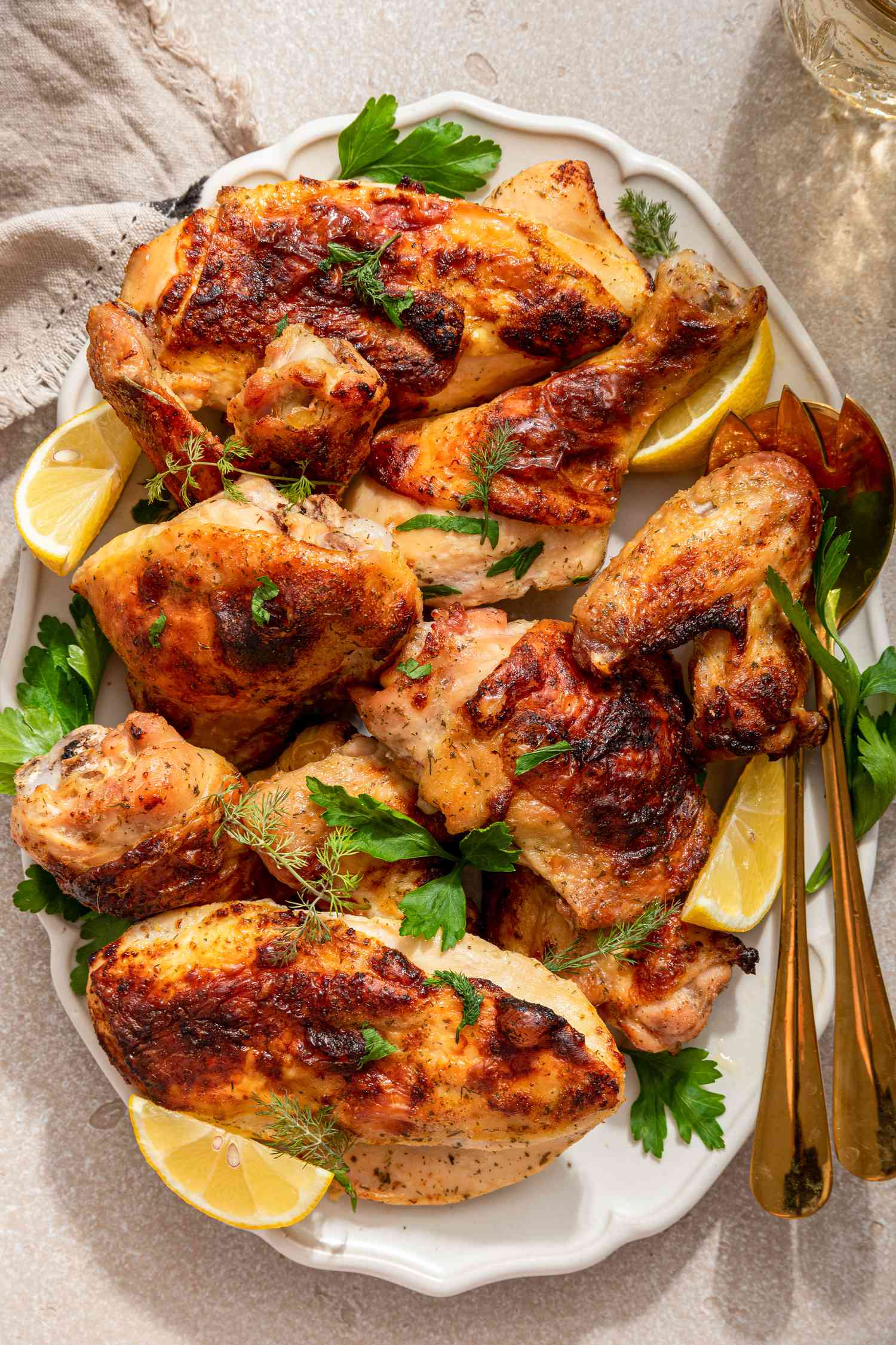 Ranch chicken topped with fresh herbs and lemon wedges on a platter