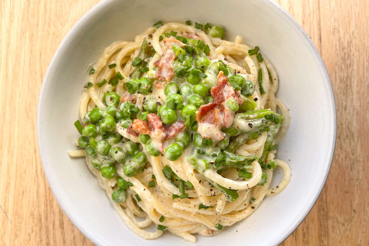 Overhead view of a bowl of Ina Garten's Easy Spring Pasta Recipe on a wooden tabletop