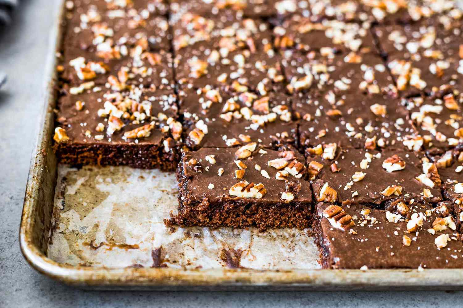 Texas chocolate sheet cake in a pan with a few pieces missing.