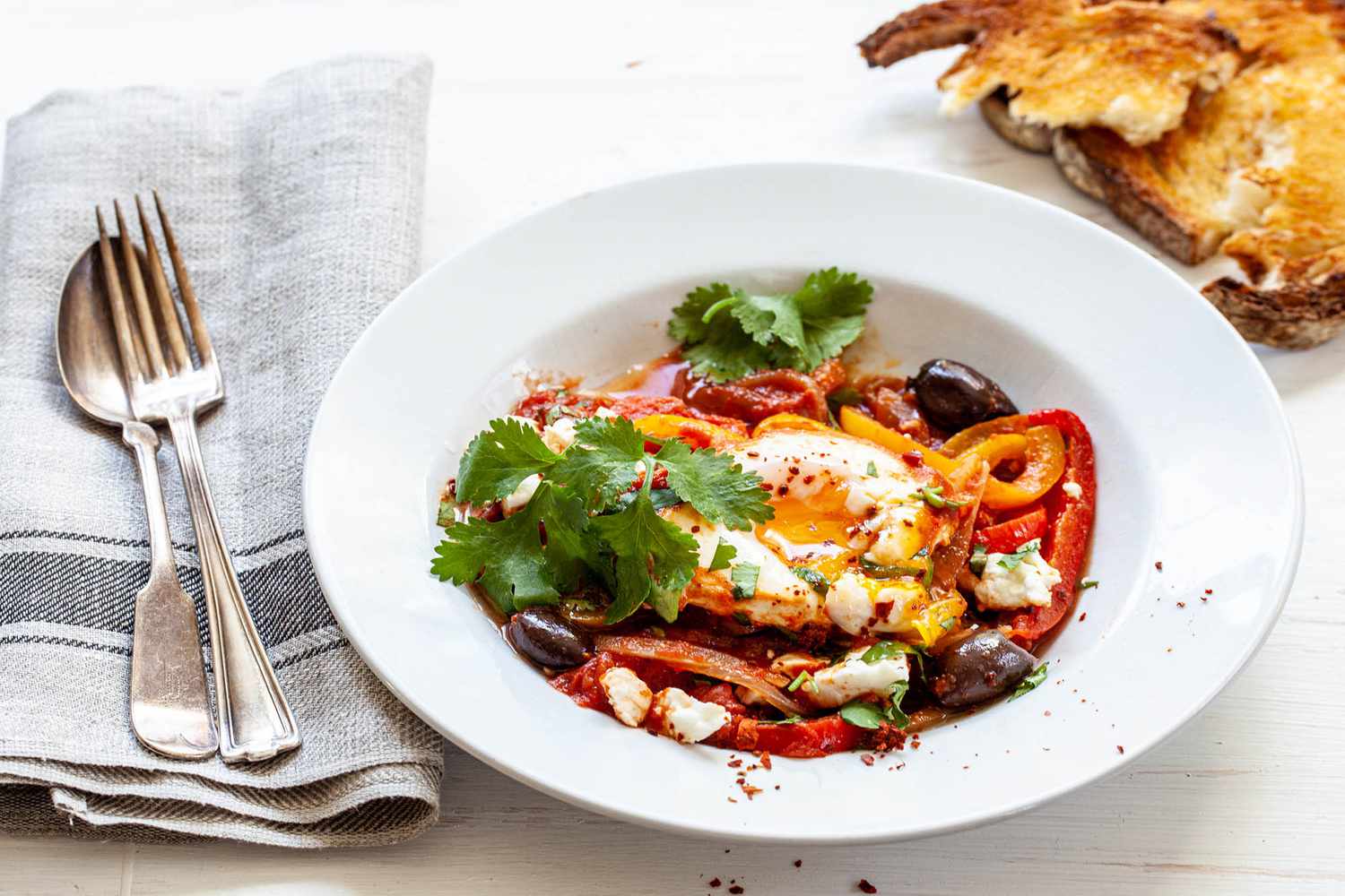 Best Shakshuka with a side of bread and topped with feta and olives.